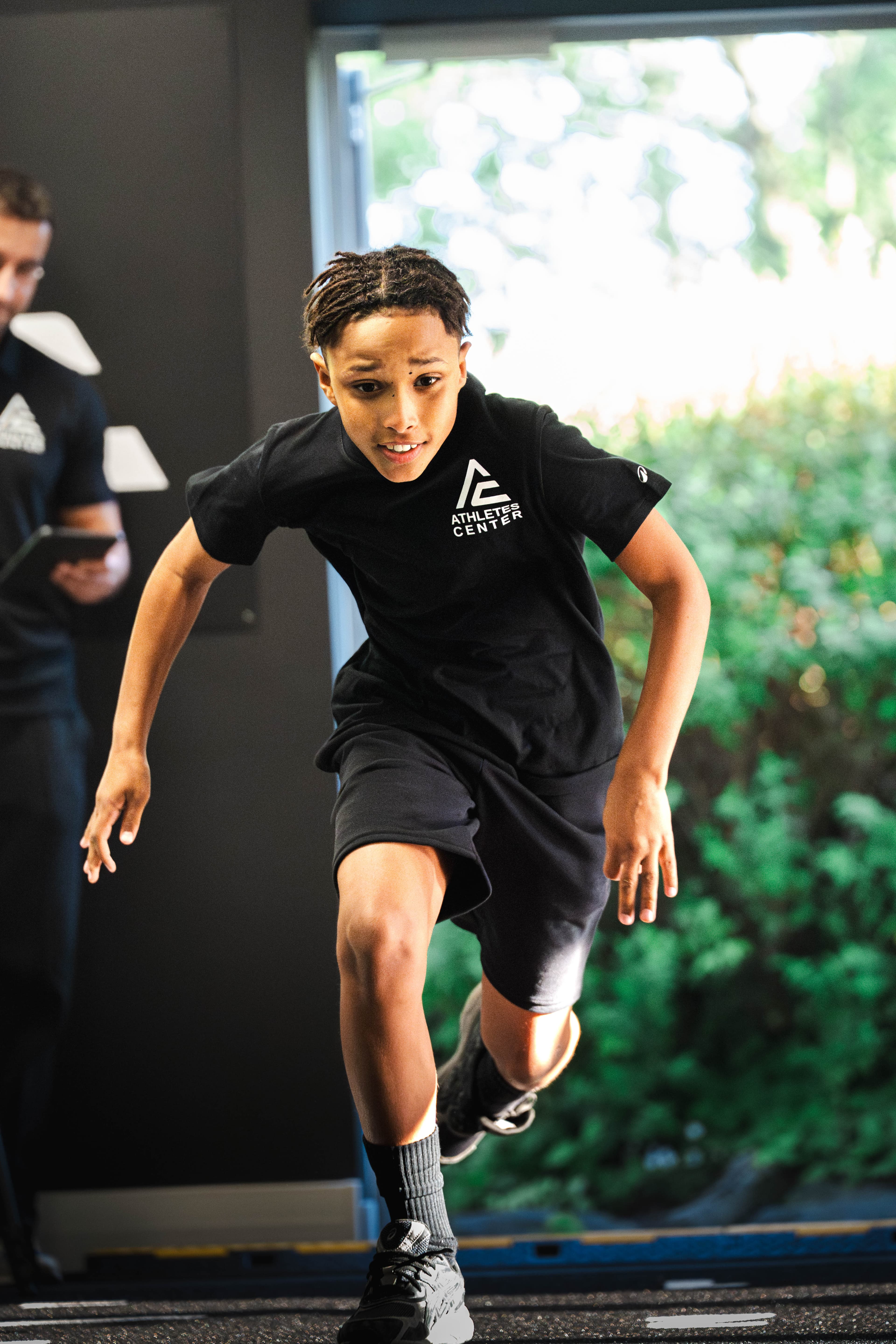 Jeune athlète Elevate en sprint test, t-shirt Athletes Center